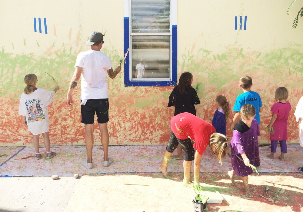 Corbin LaMont and Tom O'Toole painting a mural with kids from PACT