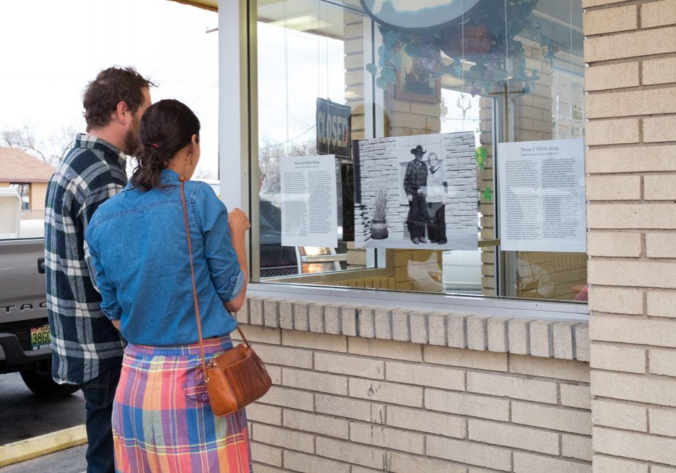Local residents read one of the narratives hanging at Chow Hound